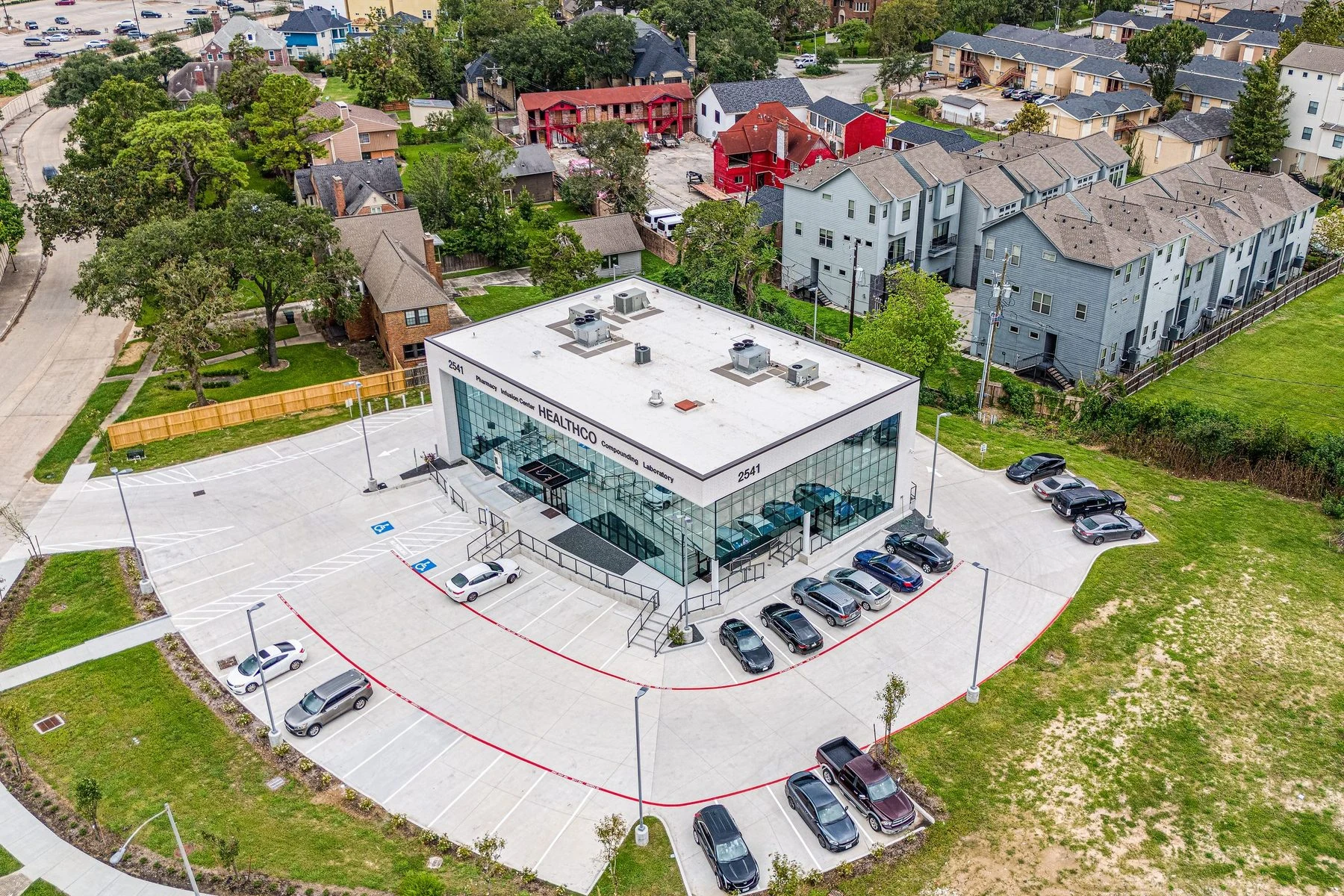 The HealthCo building at 2541 N MacGregor Way seen from above, with its glass front and car park