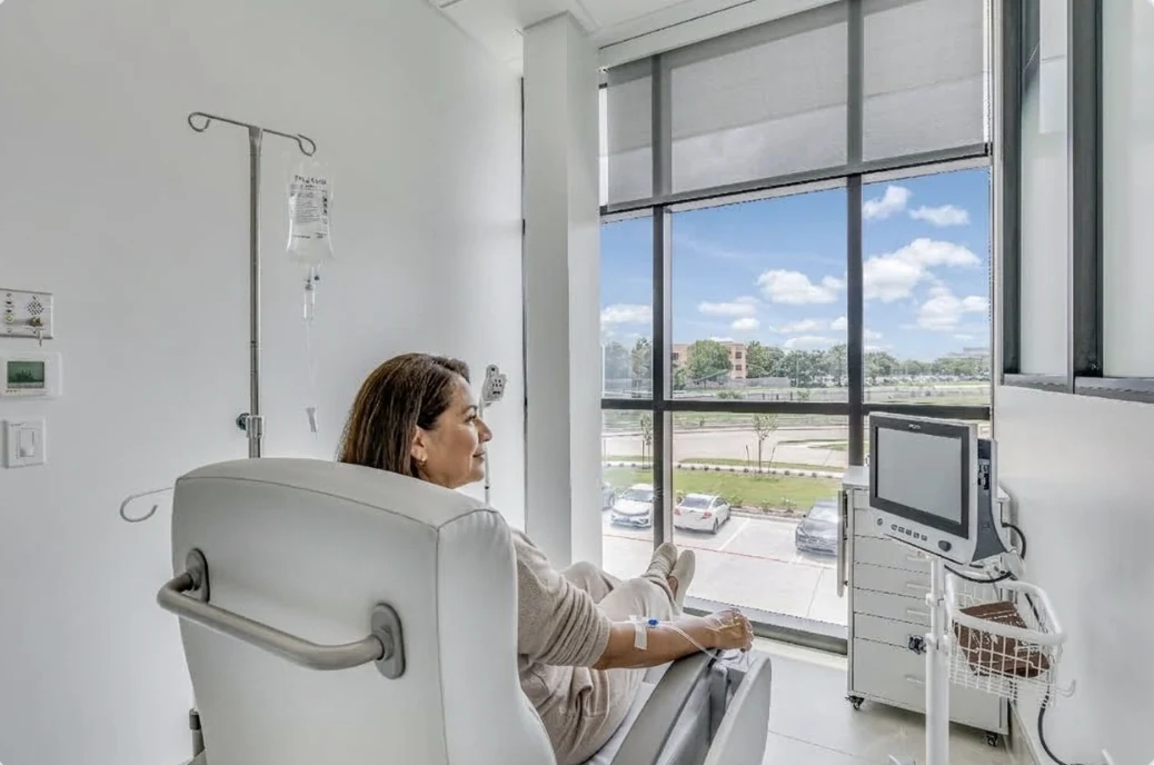 A patient relaxing in a reclining infusion chair by the window